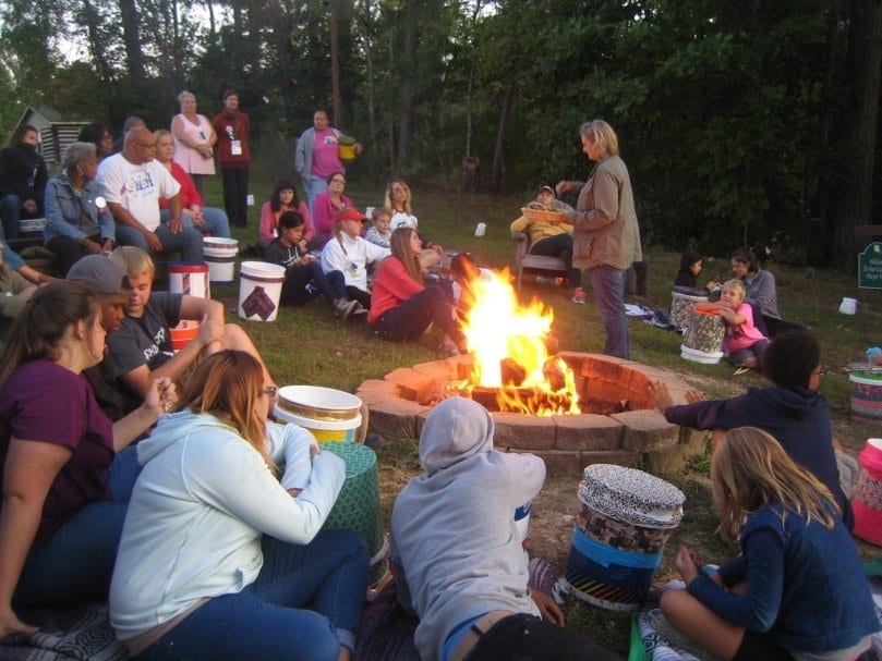 woman talking to people around campfire
