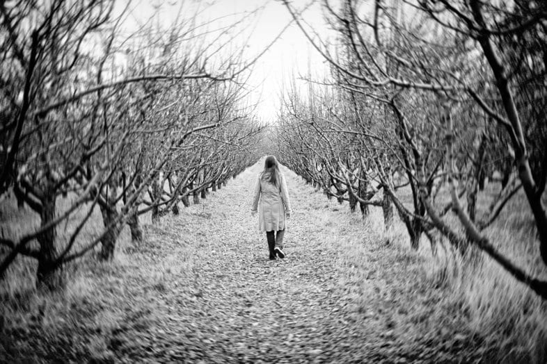 woman walking through winter trees